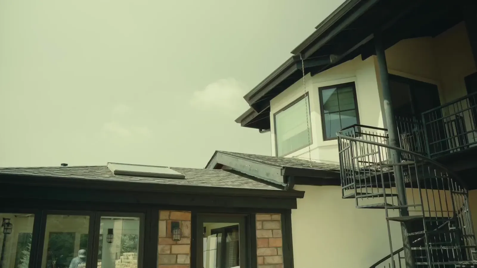 A Platinum Panes crew member cleaning windows on a Fort Collins home